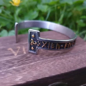 Bracelet en cuir artisanal avec fermoir métallique posé sur une surface en bois en extérieur