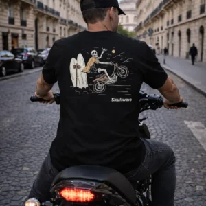 Homme portant un t-shirt noir Skull Rider avec illustration au dos en roulant en moto dans une rue urbaine
