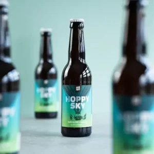 Bouteilles de bière artisanale Hoppy Sky alignées sur un comptoir avec profondeur de champ