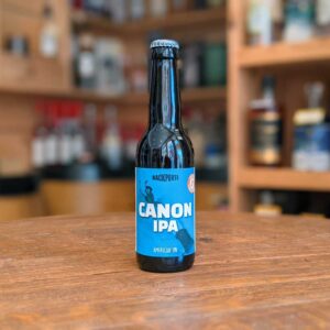 Bouteille de bière Canon IPA posée sur un comptoir de bar avec arrière-plan flou